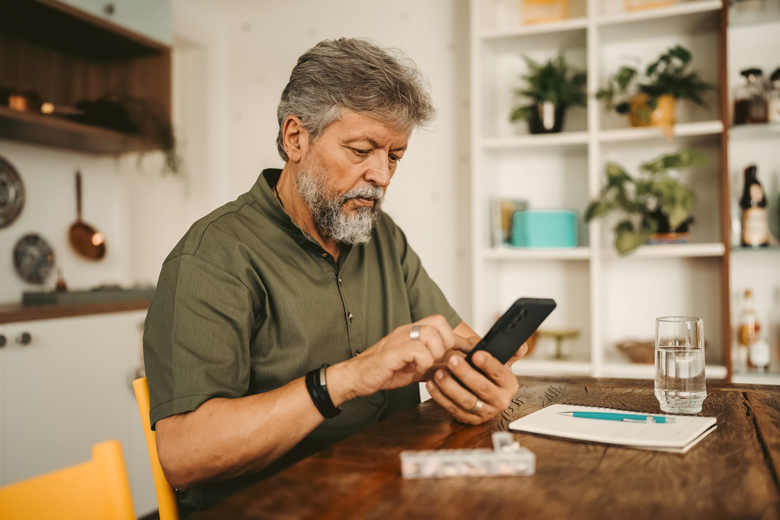 An older man in Florida using his smartphone at home to access the Playwise app for gambling support.