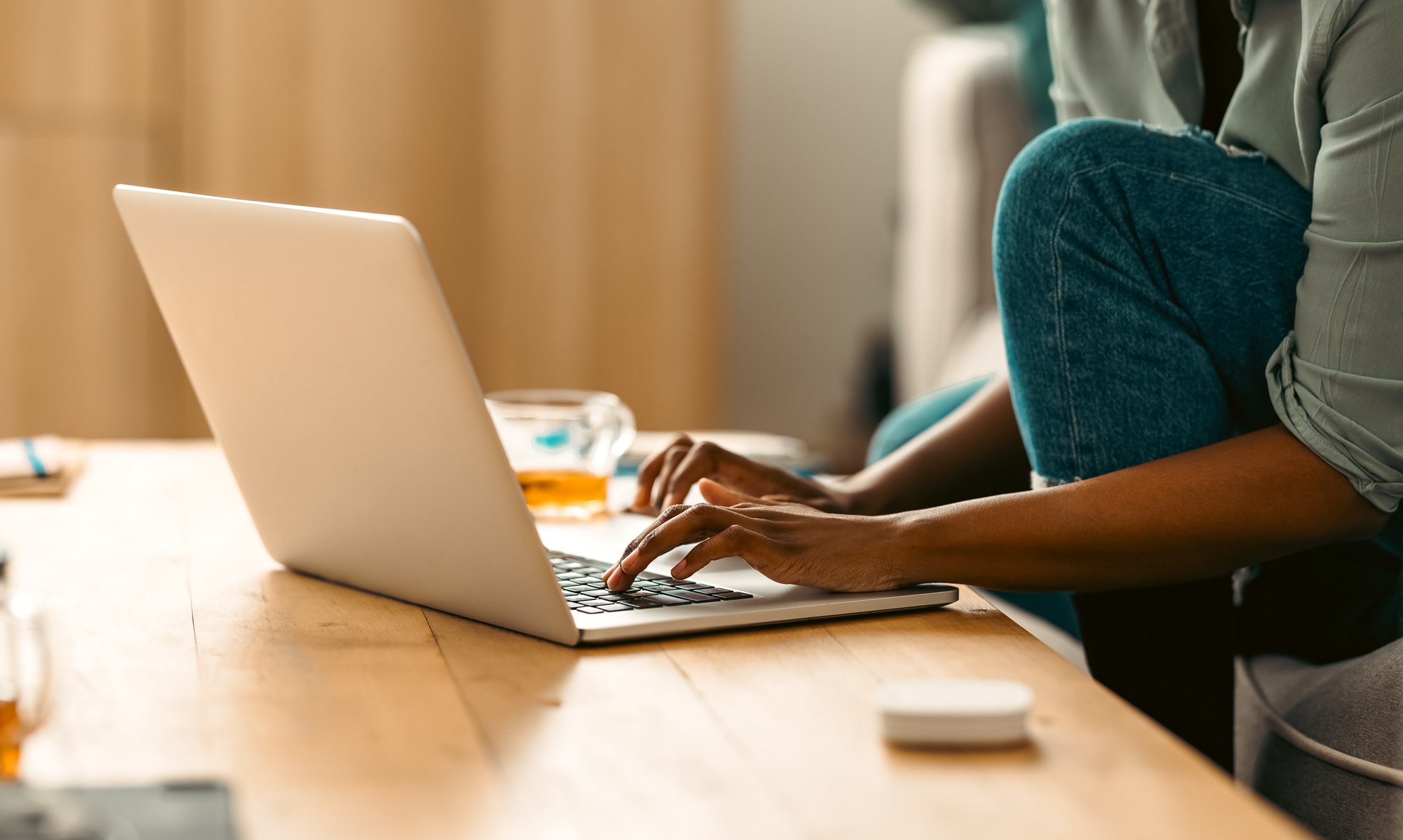 A person in Florida using a laptop at home to research gambling support options and connect with Playwise.